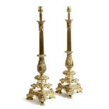 A pair of gilt brass table lamps in Regency style, each with a leaf capital above a ribbed and