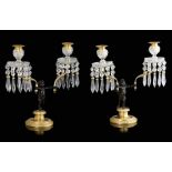 A pair of Regency gilt and patinated bronze figural twin-light lustre candlesticks, each with a