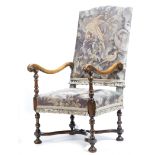 A walnut open armchair, in late 17th century style, the arched back and seat covered with