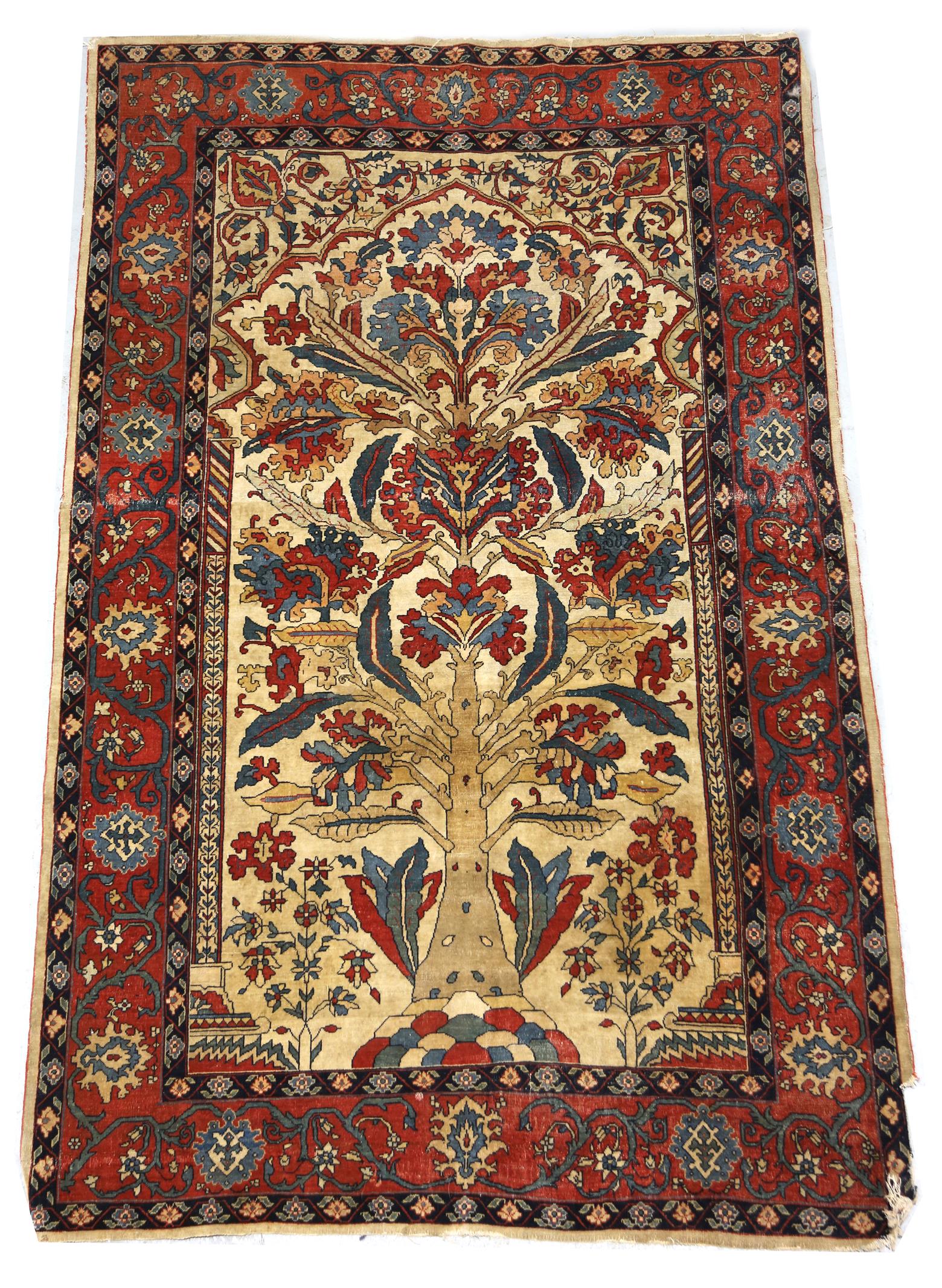 A north west Persian rug, decorated with a tree of life flanked by columns, on an ivory ground,