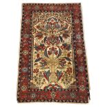 A north west Persian rug, decorated with a tree of life flanked by columns, on an ivory ground,