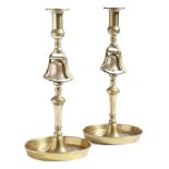 A pair of mid-Victorian brass and bell metal tavern candlesticks, each with an urn nozzle, above a