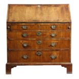 A George II walnut bureau, the hinged fall with feather and crossbanding, revealing an interior with