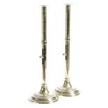 A pair of George III brass altar candlesticks, each with an ejector mechanism and a ring turned