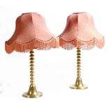 A pair of Victorian brass table lamps, each with a drip-pan, above a bobbin turned stem, on a