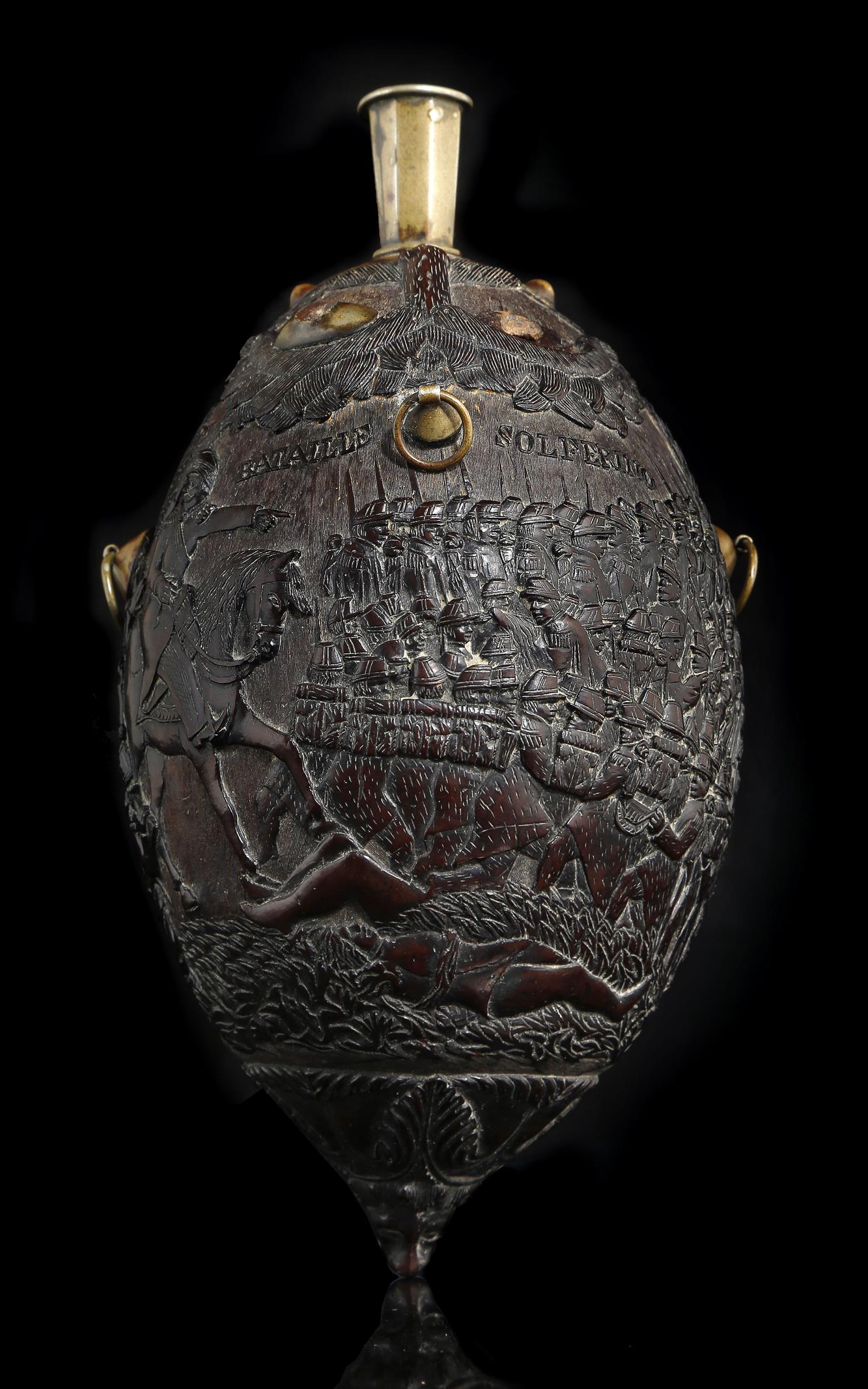 A 19th century French carved coconut bugbear flask, with brass mounts, relief decorated with the