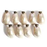 Nine mother of pearl shell lightshades, each with a brass clip mount decorated with a fleur-de-