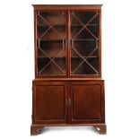 A George II mahogany bookcase cabinet, with a pair of astragal glazed doors enclosing three
