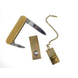 A gold penknife, with engine turned decoration, a gold cigar cutter and a gold charm depicting a car