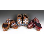 Three pairs of North American moccasins hide, leather, velvet and glass beads, including a