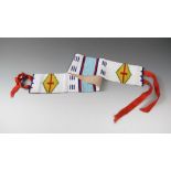 A Northern Plains beaded belt coloured glass beads, canvas and ribbon, with a white ground and three