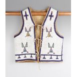 A Teton Sioux boy's vest circa 1890, buckskin with glass beads, the white ground with yellow, red,