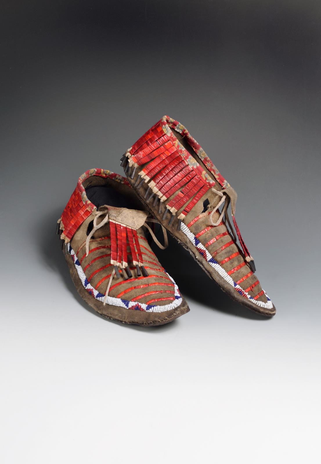 A pair of Sioux moccasins buckskin, quill, glass beads, cotton and tin, with coloured bead