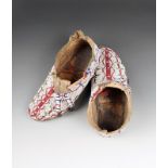 A pair of Sioux moccasins buckskin, coloured glass beads and tin cones, fully beaded with a white