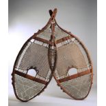 A pair of Montagnais / Naskapi snowshoes wood, babiche and cloth, of swallow tail type with