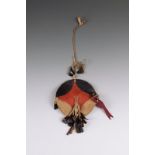 A Kiowa small shield Plains, USA buffalo hide with red and black paint and buckskin ties hung with