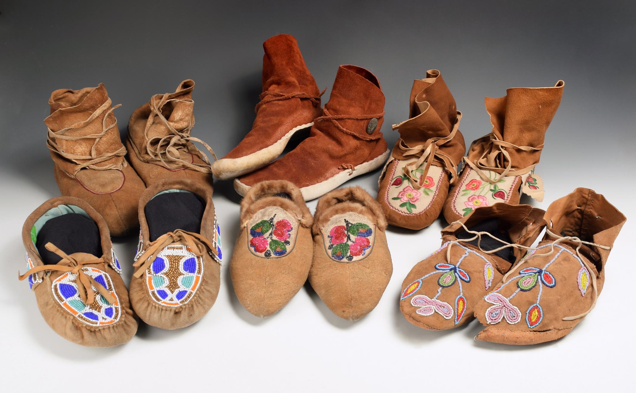 Six pairs of North American moccasins including an Athapaskan pointed toe pair with floral bead