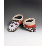 A pair of Blackfoot moccasins buckskin, glass beads and thread, with geometric decorated insteps,