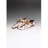 A pair of Stoney or Cree moccasins buckskin and coloured glass beads, fully beaded with a white
