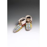 A pair of Ute moccasins hide, cloth and coloured glass beads, in yellow, light blue, white and red