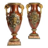 A pair of French gilt and patinated bronze urns, of amphora shape, the bodies decorated with a