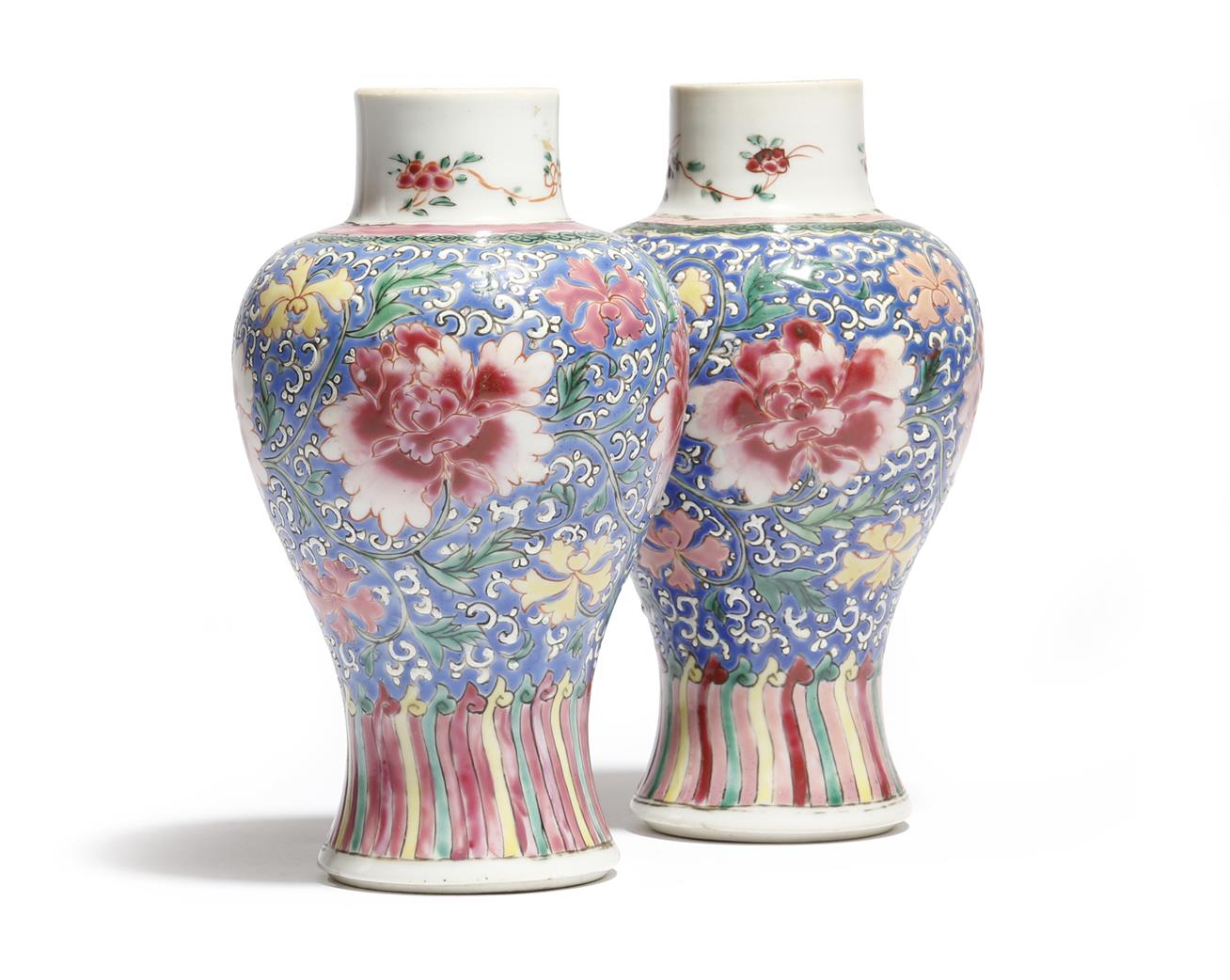 A small pair of Chinese porcelain famille rose baluster vases, decorated with flowers on a scrolling