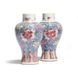 A small pair of Chinese porcelain famille rose baluster vases, decorated with flowers on a scrolling