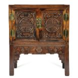 A Chinese hardwood cabinet on stand, of panelled construction, with a pair of cupboard doors