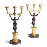 A pair early 19th century French gilt and patinated bronze figural twin-light candlesticks, each