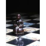 λ A rare Mughal carved ivory chess piece, of a kneeling Indian lady, above a ridged edge, with a