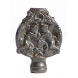 An Italian iron sword pommel, decorated on both sides with a pair of angels flanking a male mask,