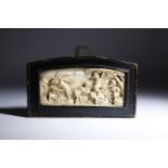 λ A European ivory panel, carved in relief with cavorting cherubs picking fruit from a tree, with