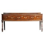 An early 18th century oak dresser, the boarded top with a moulded edge and a raised back, above