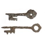 Two French Romanesque / Gothic iron keys, with pierced bow handles, 13th / 14th century, 10.7cm long