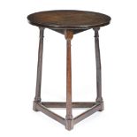 An oak cricket table, the circular top on baluster ring turned legs united by peripheral stretchers,