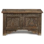 A carved oak marriage chest, the twin panelled lid decorated with coats of arms, with an eagle and
