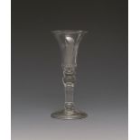 A light baluster wine glass c.1710, with a bell bowl over a flattened knop, the inverted baluster