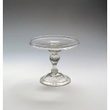 A heavy baluster glass tazza or salver c.1710, the flat circular tray with a galleried rim, raised