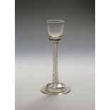 A cordial glass c.1755, the small flared bucket bowl raised on a tall double series opaque twist