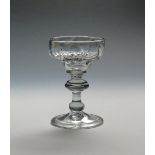 A mead or champagne glass c.1725, with pan-topped moulded bowl above a collar and annulated knop,