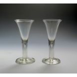 A pair of large wine glasses c.1760, the drawn trumpet bowls rising from plain stems enclosing a