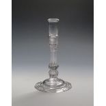 A glass candlestick c.1740, with tall cylindrical sconce rising to a folded rim, raised on a moulded