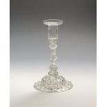 A glass candlestick c.1750, with a pan-topped moulded nozzle above a multi-knopped airtwist stem
