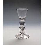 A light baluster cordial or small wine glass c.1725, the round funnel bowl supported on an egg