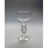 A rare cup-topped wine glass c.1720, rising from a narrow hollow base above an inverted baluster