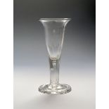 A large heavy ale glass c.1770, the drawn trumpet bowl with everted rim, rising from a thick faceted