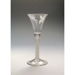 A tall Beilby wine glass c.1770, the generous drawn trumpet bowl enamelled in white with a spray