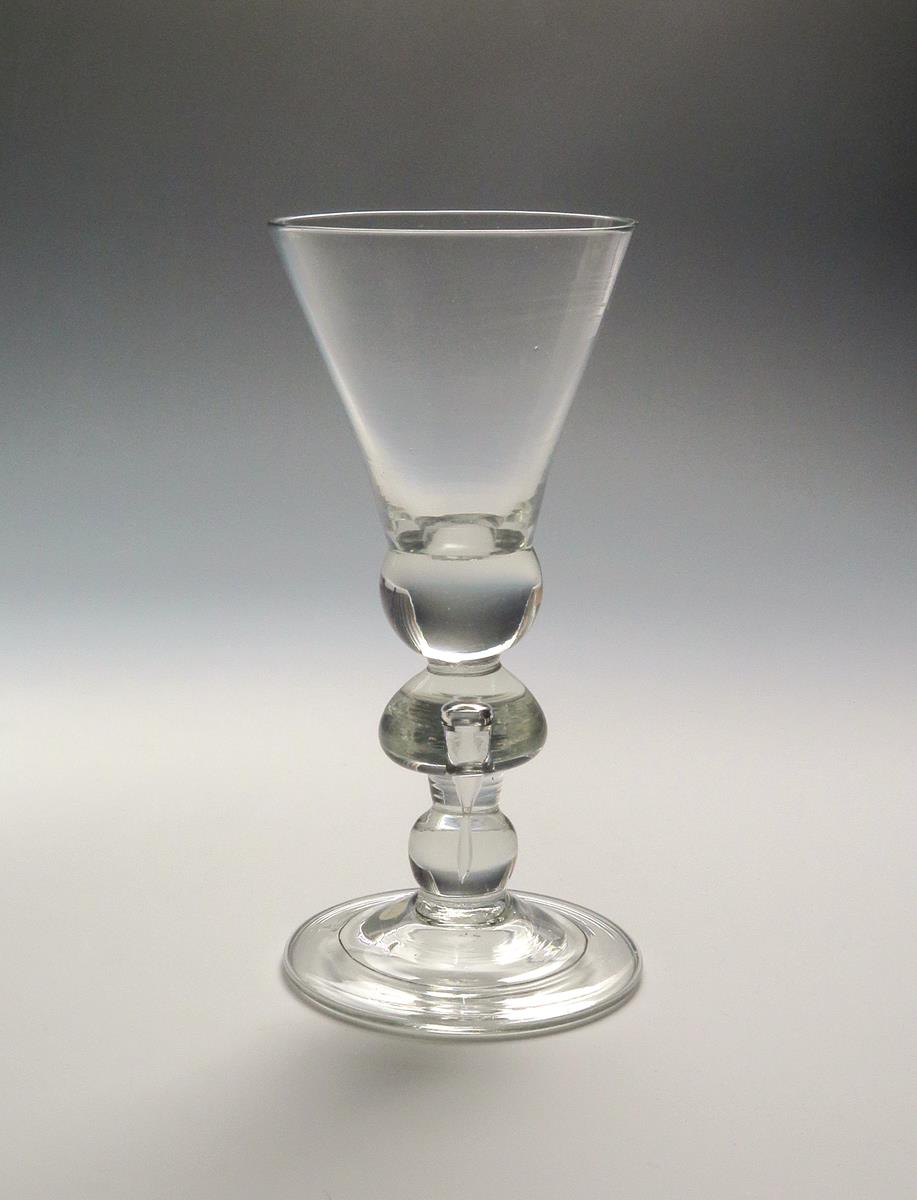 A heavy baluster goblet c.1710, the generous straight-sided thistle bowl rising from a solid ball