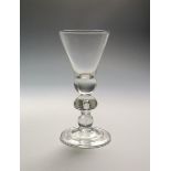 A heavy baluster goblet c.1710, the generous straight-sided thistle bowl rising from a solid ball