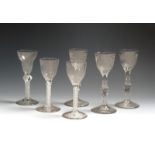 Six wine glasses c.1760-80, three with ogee bowls engraved with honeysuckle and other flowers,